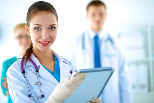 Attractive female doctor in front of medical group — Stock Photo, Image