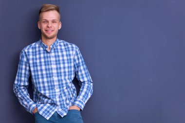 Gri arka plan üzerinde izole gülümseyen genç adam portresi