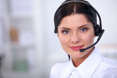 Güzel işkadını masasına kulaklık ve dizüstü çalışan portresi