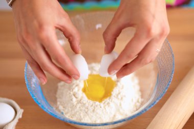 Mutfaktaki genç kadın, arka planda izole edilmiş.