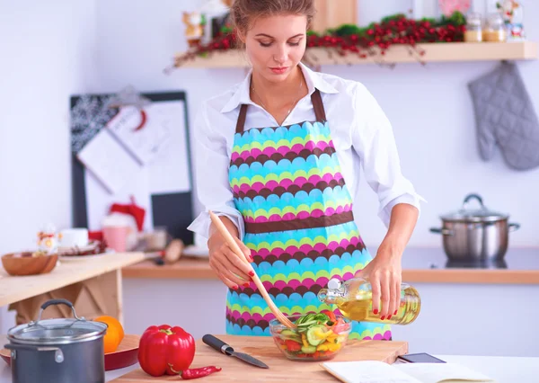 Leende ung kvinna blandar färsk sallad — Stockfoto