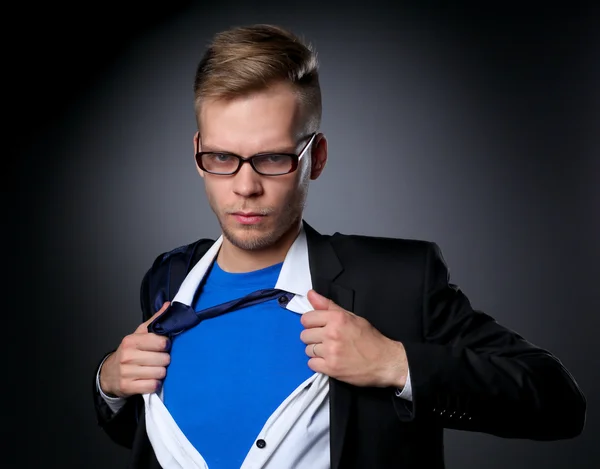 Jovem empresário agindo como um super-herói e rasgando sua camisa, isolado em fundo cinza — Fotografia de Stock