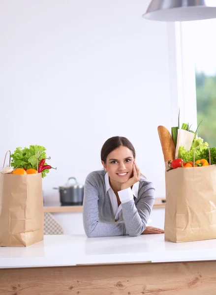 一个微笑的女人坐在厨房做饭的画像 — 图库照片