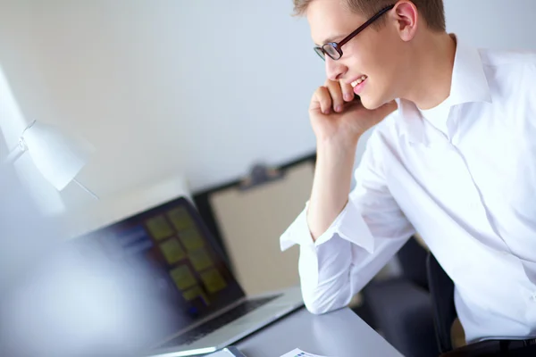 Ung affärsman arbetar på kontor, står nära skrivbord — Stockfoto