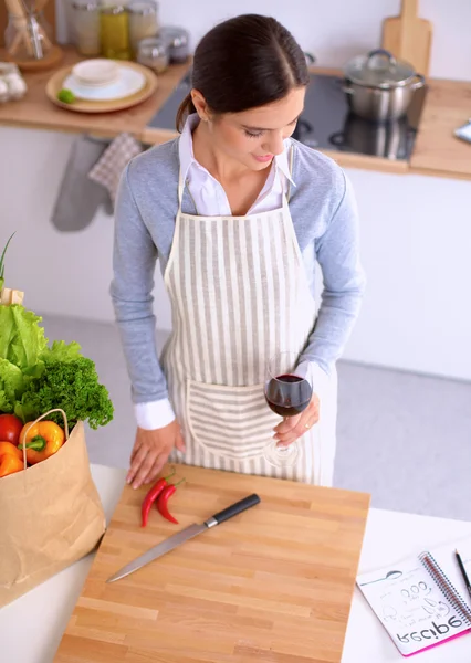 Frau mit Einkaufstaschen in der Küche zu Hause, neben Schreibtisch — Stockfoto