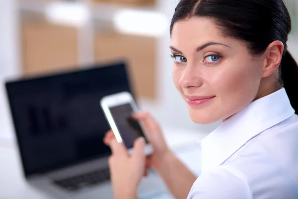 Affärskvinna skicka meddelande med smartphone sitter på kontoret — Stockfoto