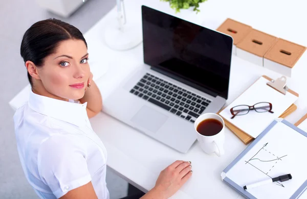 Aantrekkelijke zakenvrouw zit op het bureau in het kantoor — Stockfoto
