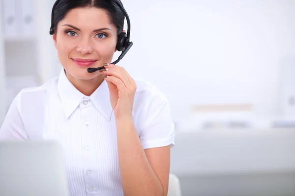 Porträt einer schönen Geschäftsfrau, die an ihrem Schreibtisch mit Headset und Laptop arbeitet — Stockfoto