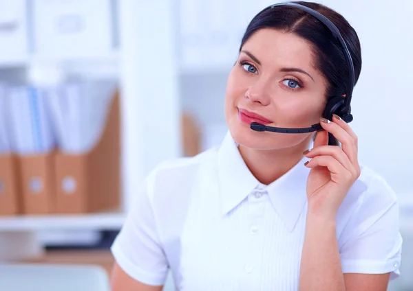 Porträt einer schönen Geschäftsfrau, die an ihrem Schreibtisch mit Headset und Laptop arbeitet — Stockfoto