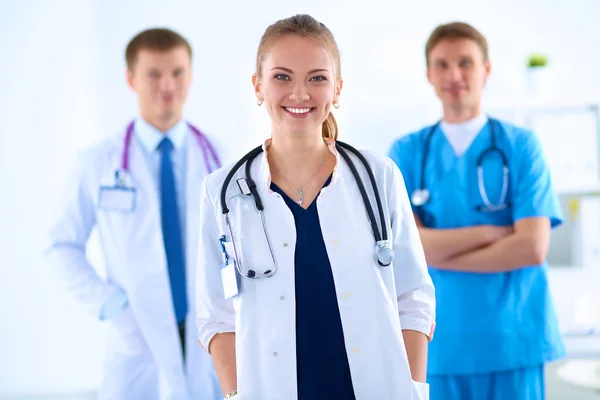 Attractive female doctor in front of medical group — Stock Photo, Image