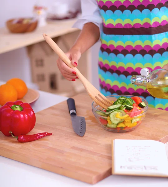 Lächelnde junge Frau mixt frischen Salat — Stockfoto