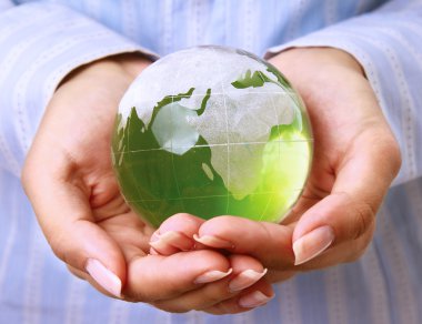 Beyaz arka plan üzerinde izole yeşil bir dünya holding eller