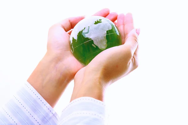 Manos sosteniendo una tierra verde, aisladas sobre fondo blanco — Foto de Stock