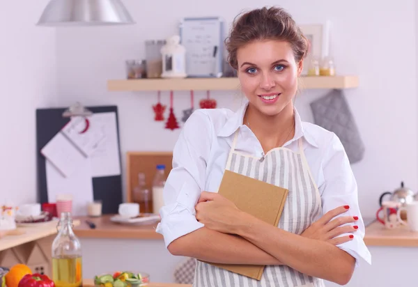 Sorridente giovane donna in cucina, in piedi su sfondo natalizio — Foto Stock