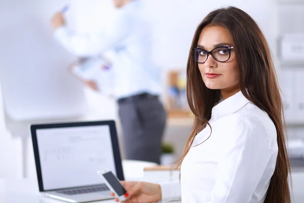 Empresária atraente sentada na mesa no escritório — Fotografia de Stock