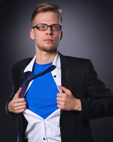 青年実業家演技スーパー ヒーローのような灰色の背景に分離された彼のシャツを引き裂く — ストック写真