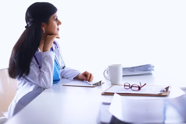 Médica sentada na mesa com papel e trabalhando — Fotografia de Stock