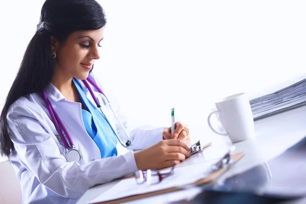 Femme médecin assis sur le bureau avec du papier et de travail — Photo