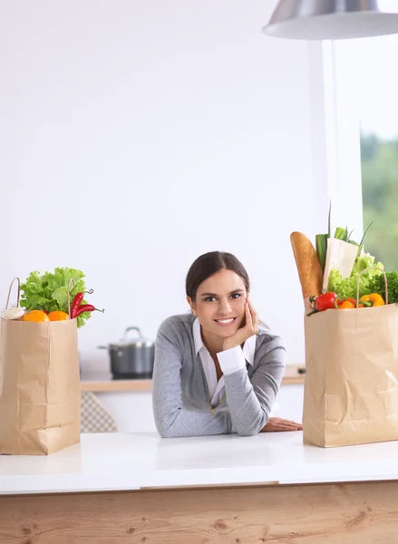 一个微笑的女人坐在厨房做饭的画像 — 图库照片