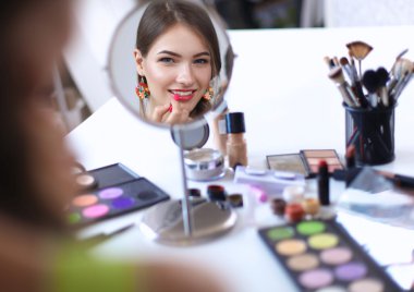 Genç güzel kadın ayna, Masa başında oturan yakınındaki makyaj yapma