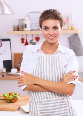 Noel arka plan üzerinde duran mutfakta gülümseyen genç kadın