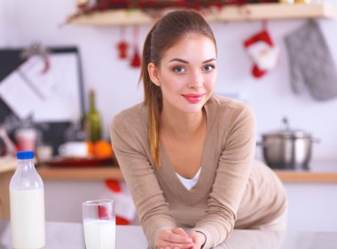 Gülümseyen çekici kadın mutfağın içinde kahvaltı yapıyor.