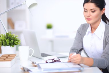 Ofiste masa başında oturan çekici bir iş kadını.