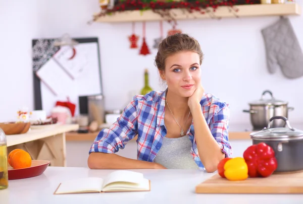 Mujer joven sonriente en la cocina, aislada en el fondo de Navidad —  Fotos de Stock