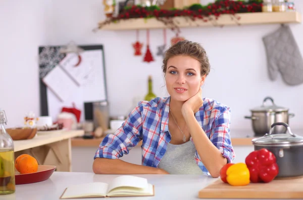 Mujer joven sonriente en la cocina, aislada en el fondo de Navidad —  Fotos de Stock