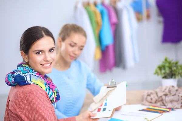 Jovem designer de moda feminina atraente trabalhando na mesa de escritório, desenhando enquanto fala no celular — Fotografia de Stock