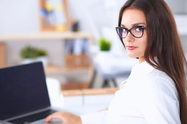 Empresária atraente sentada na mesa no escritório — Fotografia de Stock