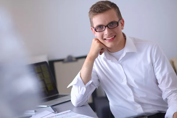 Ung affärsman arbetar på kontor, står nära skrivbord — Stockfoto