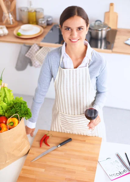 Mutfakta alışveriş torbaları olan bir kadın, masanın yanında duruyor. — Stok fotoğraf
