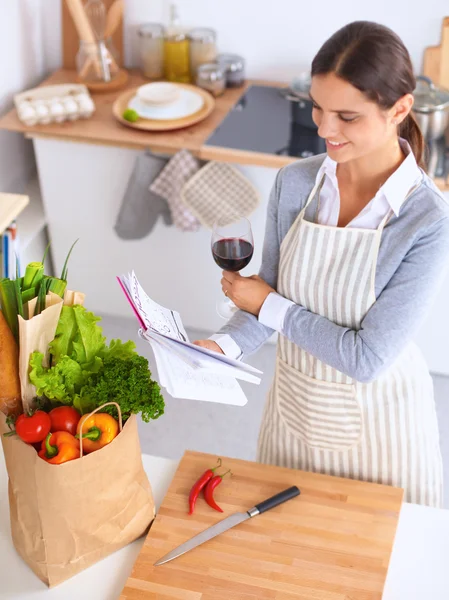 Vrouw met boodschappentassen in de keuken thuis, bij het bureau — Stockfoto