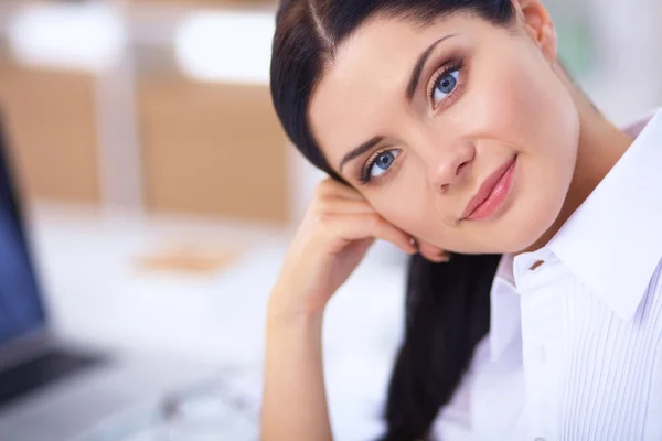 Aantrekkelijke zakenvrouw zit op het bureau in het kantoor — Stockfoto