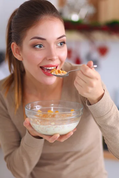 Leende attraktiv kvinna som äter frukost i köket interiör — Stockfoto