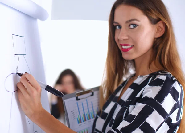 Young woman standing near board with folder — Stock Photo, Image