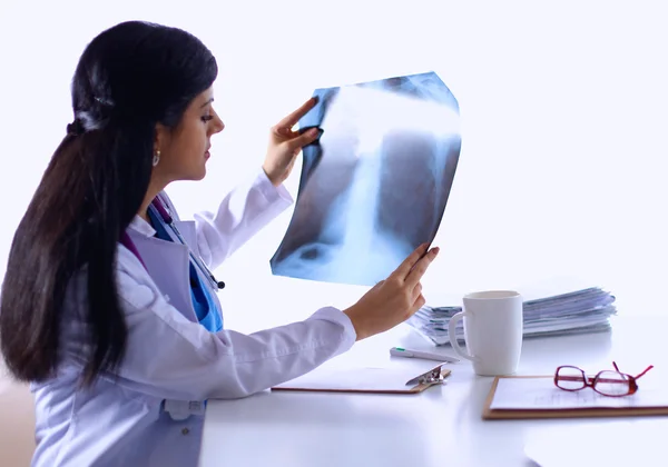 Genç bayan doktor röntgen üzerinde çalışıyor, masada oturuyor. — Stok fotoğraf