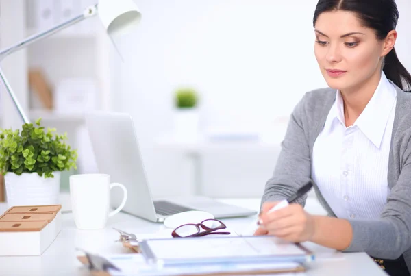 Attraktive Geschäftsfrau sitzt auf Schreibtisch im Büro — Stockfoto