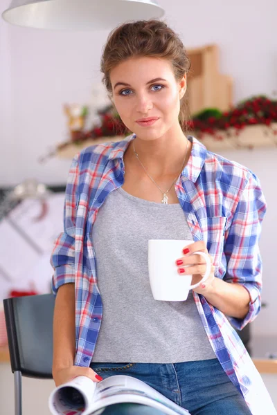 Donna che legge mgazine In cucina a casa — Foto Stock