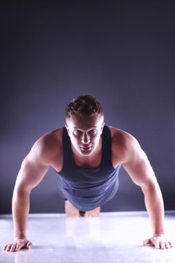 Gönderme yapan fitness erkek ups katta, izole gri arka plan