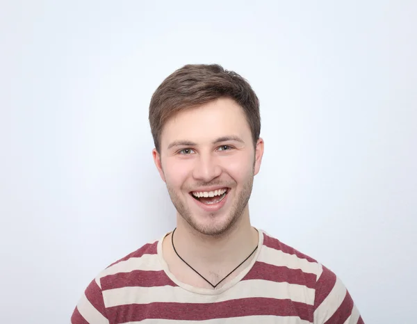 Retrato del joven sonriendo aislado sobre fondo gris —  Fotos de Stock