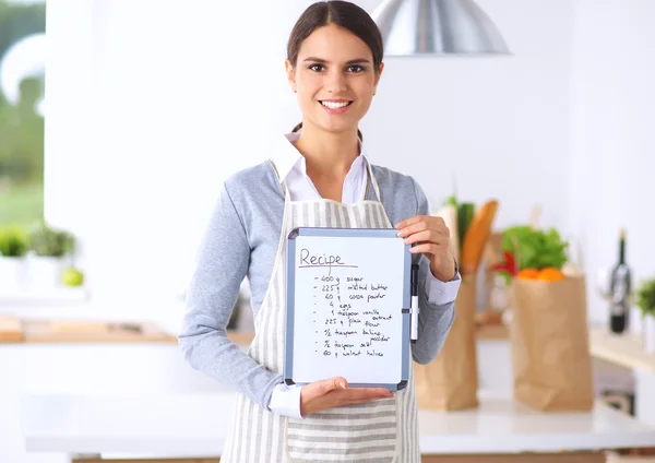 Vrouw in de keuken thuis, in de buurt van bureau met map — Stockfoto