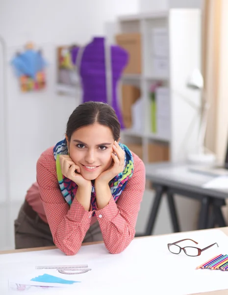 Jonge aantrekkelijke vrouwelijke mode-ontwerper werken op kantoor bureau, tekenen terwijl het praten op mobiele — Stockfoto