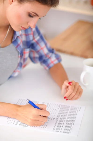 Junge Frau schreibt etwas in ihren Notizblock — Stockfoto