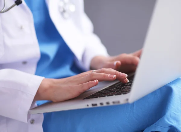 Vrouwelijke arts werken geïsoleerd op grijze achtergrond — Stockfoto