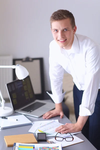 Mladý podnikatel pracují v kanceláři, stojící poblíž stůl — Stock fotografie