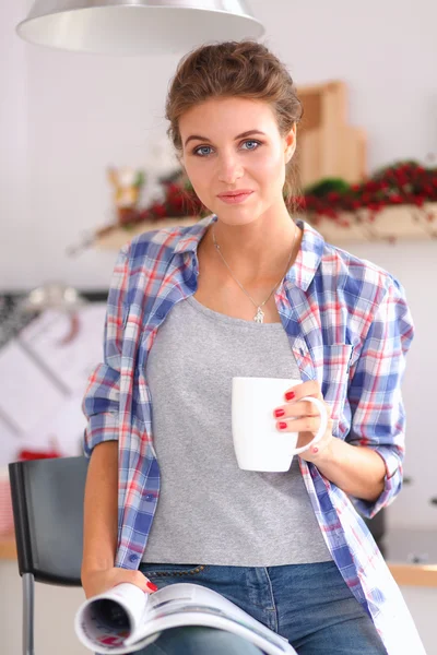 Mujer leyendo mgazine En la cocina en casa — Foto de Stock