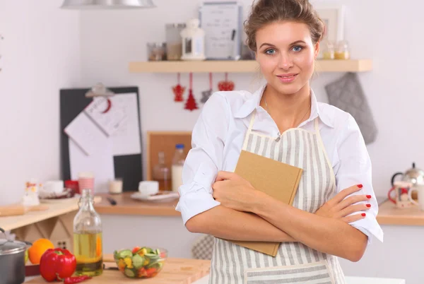 Sorridente giovane donna in cucina, isolata su sfondo natalizio — Foto Stock