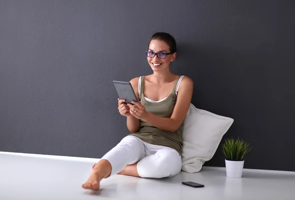 Tablet ile katta oturan çekici beyaz kız — Stok fotoğraf
